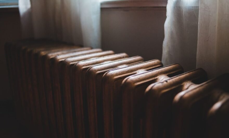 old radiator near windowsill at home in daylight